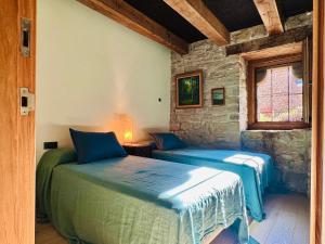 twee bedden in een kamer met een stenen muur bij Equisoain in Monreal