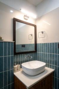 a bathroom with a sink and a mirror at Ahrin House-entire villa with kitchen and parking in Dharmsala