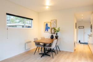 Un comedor con mesa y sillas de madera. en Chalet Vlinder, en Haarle