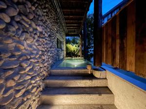 a set of stairs leading up to a stone wall at Heidi Guest House in Yuzawa