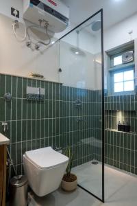 a bathroom with a toilet and a glass shower at Ahrin House-entire villa with kitchen and parking in Dharmsala