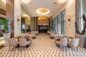 a restaurant with tables and chairs in a room at Riu Plaza Panamá in Panama City