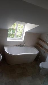 a white bath tub in a bathroom with a window at Yew Tree Cottage in Bristol