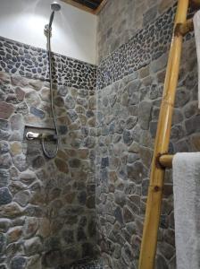 a stone shower in a bathroom with a stone wall at Villa Ilo Komba in Ampangorinana +2 photos