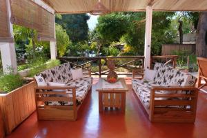 a screened in porch with couches and a table at Villa Ilo Komba in Ampangorinana