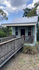 a small blue house with a wooden porch at Lakefront Cabin Rental in Bradenton, Florida in Eastgate