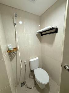 a bathroom with a white toilet and a shower at Apartemen OSAKA Riverview PIK2 Studio By GPI in Rawalumpang