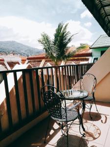 una mesa y sillas en un balcón con vistas en Boomerang Inn, en Patong Beach