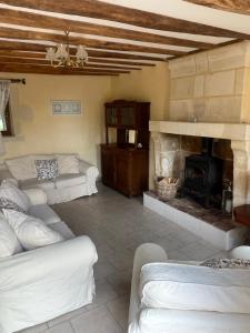 ein Wohnzimmer mit weißen Sofas und einem Kamin in der Unterkunft L'Hirondelle in Le Petit-Pressigny + 1 Foto