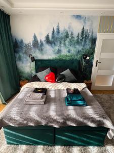 a bedroom with a green bed with a painting on the wall at Twoje prywatne SPA - jacuzzi, sauna, tężnia solankowa in Kraków
