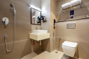 a bathroom with a toilet and a sink and a shower at Monday Premium Madhapur in Hyderabad +8 photos