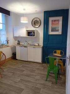 een keuken met een tafel en een blauwe muur bij Marc 2 in Saint-Valéry-en-Caux