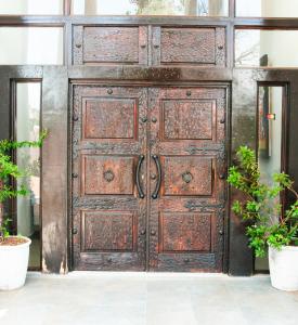 an old wooden door in a building with two potted plants at Miyanwe in Pretoria