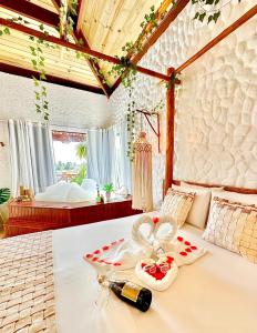 a bedroom with a bed with a bottle of champagne at BANGATACHO - Bangalôs Temáticos com Experiências Românticas Exclusivas - Praia do Patacho in Pôrto de Pedras