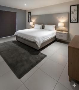 Un dormitorio con una gran cama blanca y dos lámparas. en Msotra Party House, en Soweto