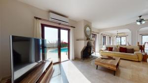 un salon avec une grande télévision à écran plat dans l'établissement Villa Tranquillity, à Kharcha