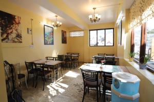 a dining room with tables and chairs and windows at Harmony Sentiments in Shimla