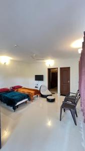 a bedroom with a bed and a chair in it at Vivens Villas in Ooty +7 photos
