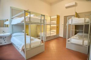 Una cama o camas en una habitación de Lucca Hostel & Rooms San Frediano