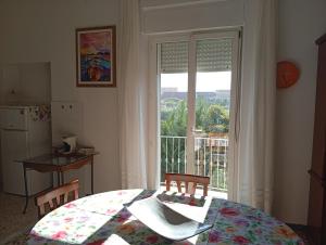 a kitchen with a table and a window with a view at La Casa di Anna in Sassari
