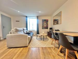 una sala de estar con un sofá y una mesa en Le souvenir Spacieux t2 aux portes du Futuroscope, en Saint-Georges-lès-Baillargeaux