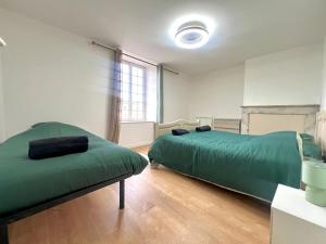 Un dormitorio con una cama verde y una ventana. en Le souvenir Spacieux t2 aux portes du Futuroscope, en Saint-Georges-lès-Baillargeaux