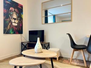 una sala de estar con una mesa y un cuadro de un león en Le souvenir Spacieux t2 aux portes du Futuroscope, en Saint-Georges-lès-Baillargeaux