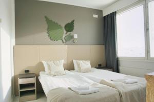 a bedroom with two beds with towels on them at Hotelli Savonlinna in Savonlinna