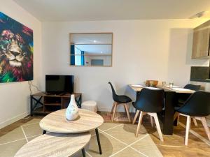 Una sala de estar con sillas y una mesa y un cuadro. en Le souvenir Spacieux t2 aux portes du Futuroscope, en Saint-Georges-lès-Baillargeaux 6 fotos más