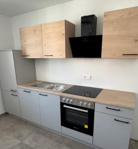 a kitchen with white cabinets and a stove top oven at Stadtquartier Völkermarkt in Völkermarkt