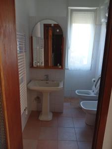 a bathroom with a sink and a toilet and a mirror at La Casa di Anna in Sassari