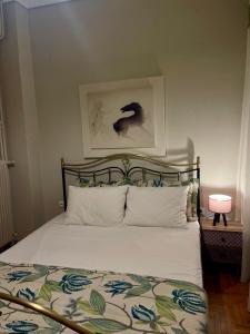 a bedroom with a bed and a picture of a horse at Chari's Apartment in Tríkala