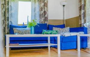 a blue couch with pillows on it in a living room at Amazing Home In Bjärtrå With Sauna in Bjärtrå