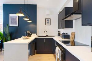 una cucina con armadi in bianco e nero e un lavandino di New! 3BR in Gladstone a Hartlepool