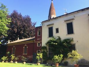 an old building with a tower on top of it at Garden Loft by Veneto Villa in Villa Osti +7 photos