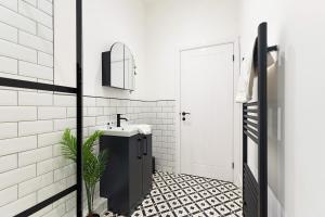 un bagno con pavimento piastrellato in bianco e nero e lavandino. di New! 3BR in Gladstone a Hartlepool Altre 36 foto