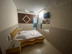 a small bedroom with a bed and a mirror at Namorata Expo Inn in São Paulo