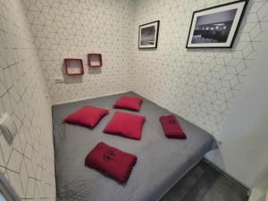 a room with a bed with red pillows on it at Mieszkanie z tarasem - Rybacka in Władysławowo