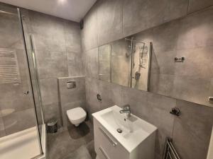 a bathroom with a toilet and a sink and a shower at Mieszkanie z tarasem - Rybacka in Władysławowo +2 photos
