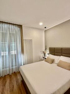 a bedroom with a large white bed and a window at Sweet Rooms in La Spezia
