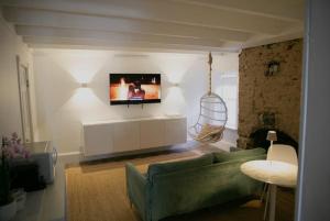 ein Wohnzimmer mit einem Sofa und einem Fernseher an der Wand in der Unterkunft Bosch Huis Rosé - Entire Property in Savannah