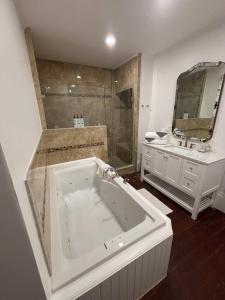 ein Badezimmer mit großer Badewanne und Waschbecken in der Unterkunft Bosch Huis Rosé - Entire Property in Savannah + 27 Fotos