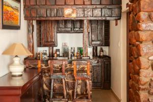 a kitchen with a bar with two chairs and a table at Miyanwe in Pretoria