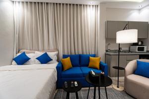 a bedroom with a blue bed and a couch at A distinctive and upscale studio in Salamanca 112 in Riyadh