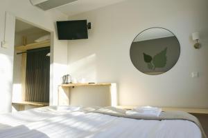 een slaapkamer met een bed en een spiegel aan de muur bij Hotelli Savonlinna in Savonlinna