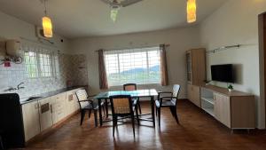 a kitchen with a table and chairs in a room at Vivens Villas in Ooty