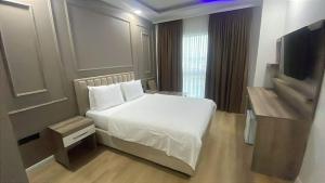 een hotelkamer met een bed en een televisie bij İdil Haznedar Otel in İdil