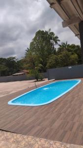 a large blue swimming pool on a wooden deck at COP30 - Sitio em Benevides in Benevides