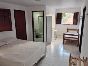 ein Schlafzimmer mit einem Bett und ein Badezimmer in der Unterkunft casa temporada praia de sonho verde, Paripueira - Alagoas in Paripueira + 13 Fotos