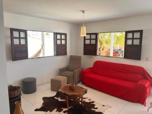 ein Schlafzimmer mit einem roten Bett und einem Stuhl in der Unterkunft casa temporada praia de sonho verde, Paripueira - Alagoas in Paripueira